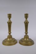 A pair of antique brass column candlesticks, 25cm high
