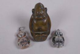 A silver Billiken charm, Birmingham 1910, 2.5cm long, and another, 1909, Reg 531531, and a filled