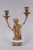 A gilt metal two branch candlestick in the form of a putti, 30cm high
