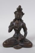 An antique Tibetan bronze figure of Buddha holding a vajra and bell, 16cm high