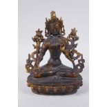 A Sino Tibetan bronze figure of a female deity seated on a lotus throne, with the remnants of gilt