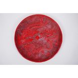 A Chinese cinnabar lacquer style charger with phoenix and dragon decoration, character inscription