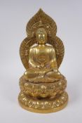 A Sino Tibetan gilt metal figure of Buddha seated on a lotus flower, impressed 4 character mark to