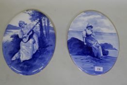 A pair of Royal Doulton blue and white painted porcelain plaques with gilt rims, 36cm long