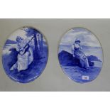 A pair of Royal Doulton blue and white painted porcelain plaques with gilt rims, 36cm long