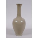 A Chinese porcelain vase with a buff glaze and slender neck, 20cm high