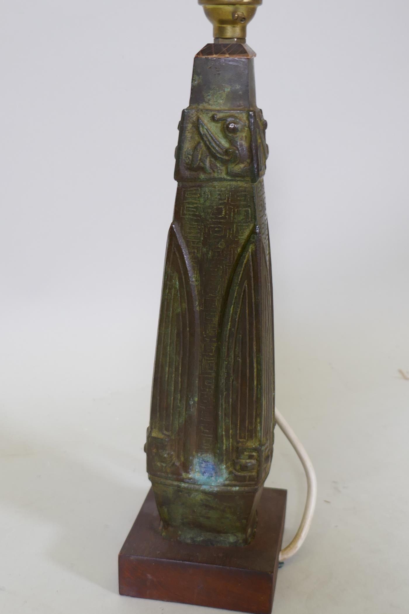 A bronze table lamp with oriental inspired raised decoration, mounted on a wood base, 32cm high - Image 2 of 2