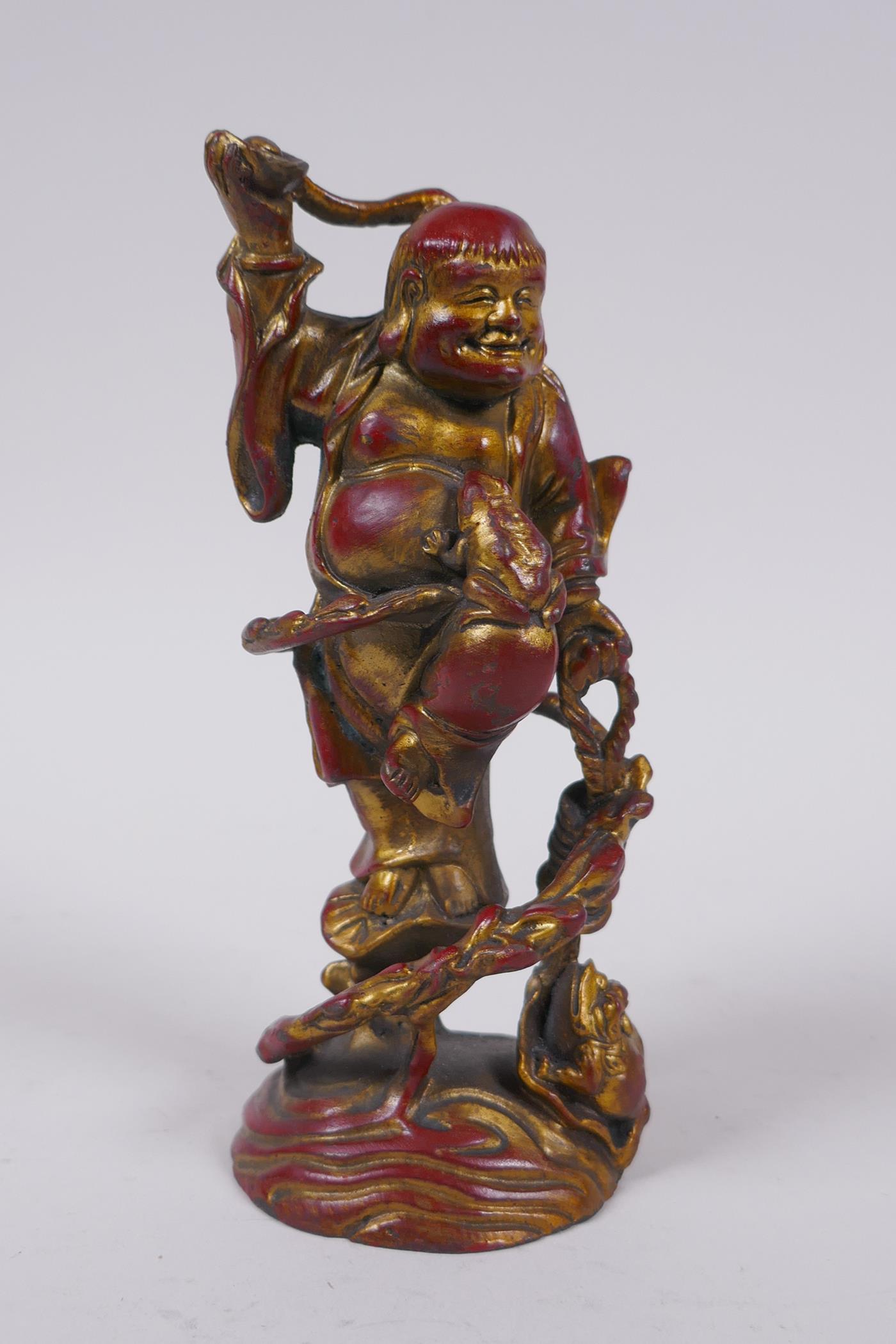 A Chinese gilt and coppered bronze Lohan and toads, 16cm high