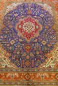 Large Persian carpet on a rich blue ground and multicolour field, with burnt orange border,