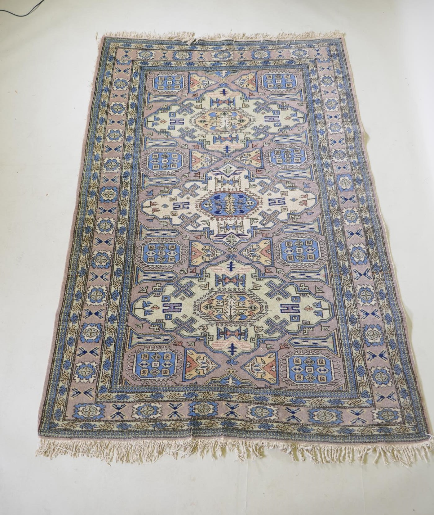 An antique Persian faded pink ground wool carpet with a green geometric medallion design, 140 x - Image 2 of 5