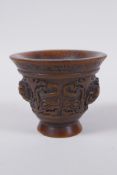 A Chinese faux horn libation cup with raised kylin decoration, seal mark to base, 8cm high x 10cm