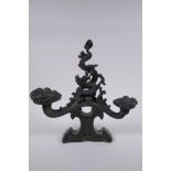 A Chinese filled bronze ornament in the form of a ruyi surmounted by a dragon with a character