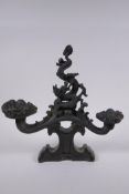 A Chinese filled bronze ornament in the form of a ruyi surmounted by a dragon with a character