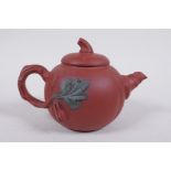 A Chinese YiXing pottery teapot in the form of a gourd, with a branch handle and leaf spout,