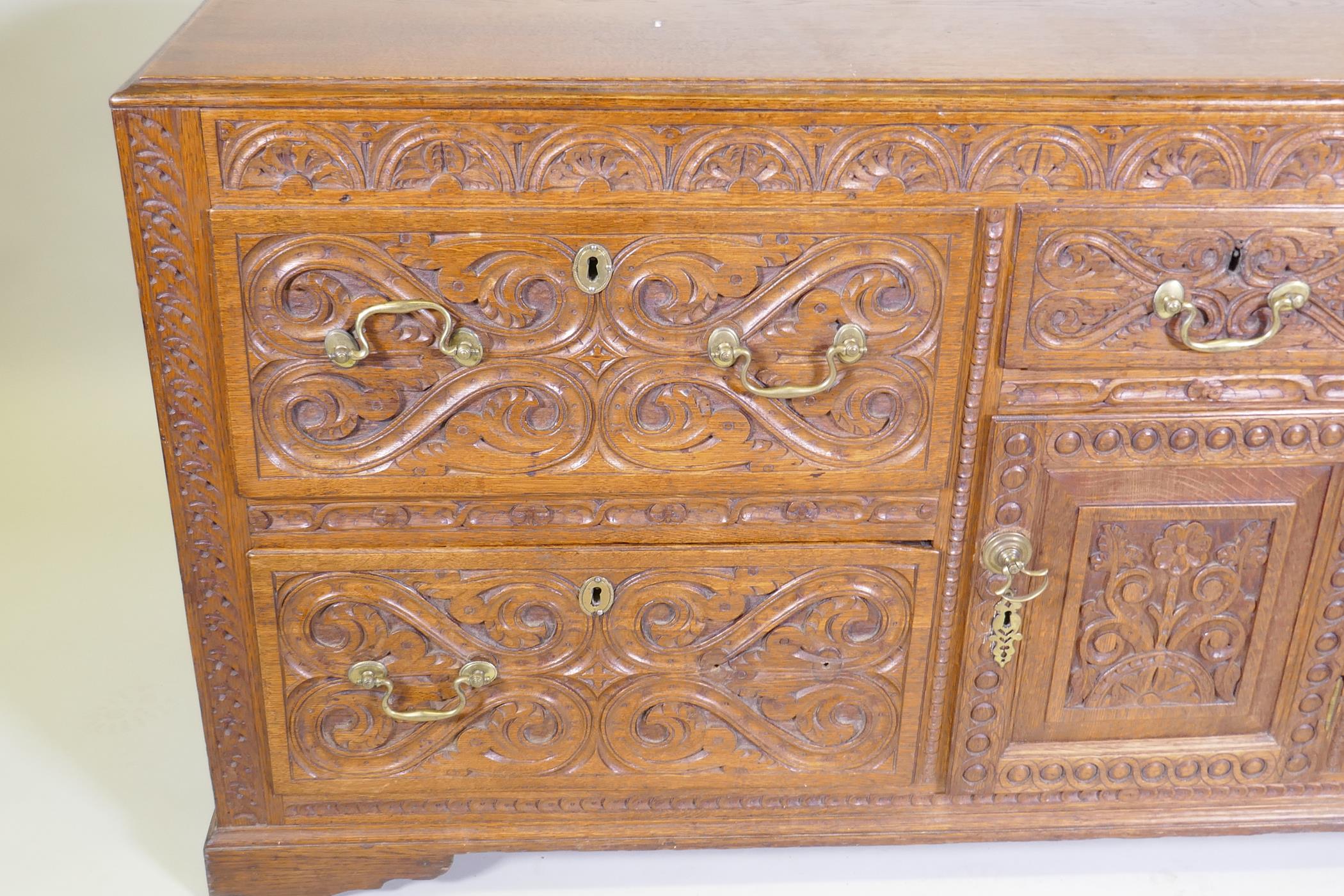 A carved oak sideboard/buffet with five drawers and a single door, with brass swan neck handles, - Image 2 of 3