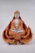 A Chinese orange glazed porcelain figure of Buddha seated within a lotus flower, impressed marks