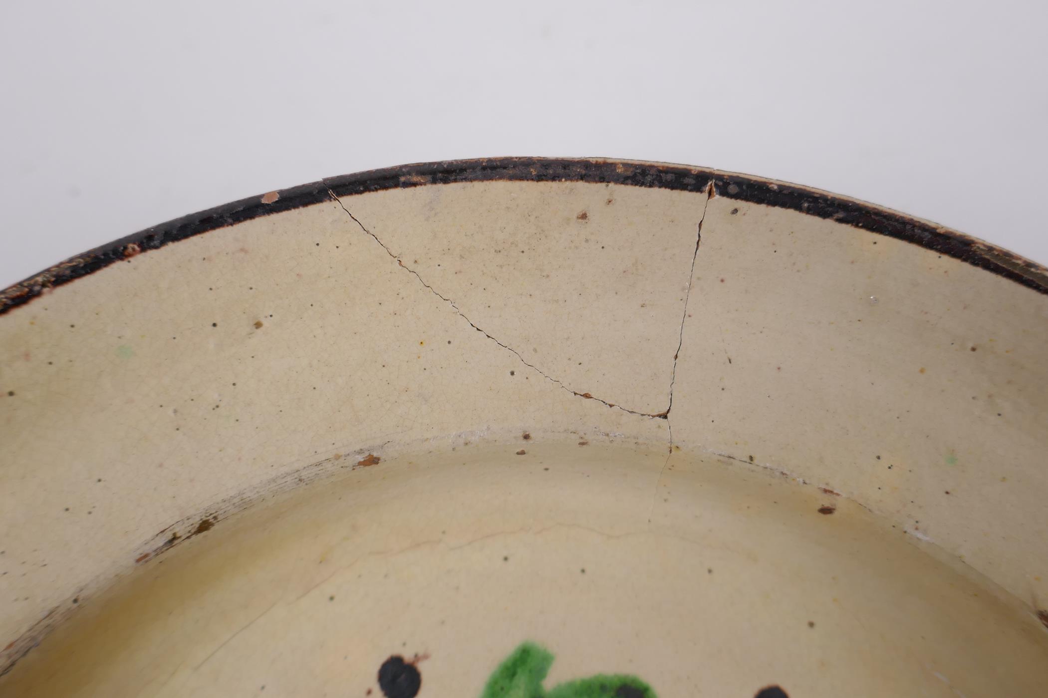 An antique Spanish terracotta dish with a faience glaze and floral decoration, AF repair, 21cm - Image 5 of 6