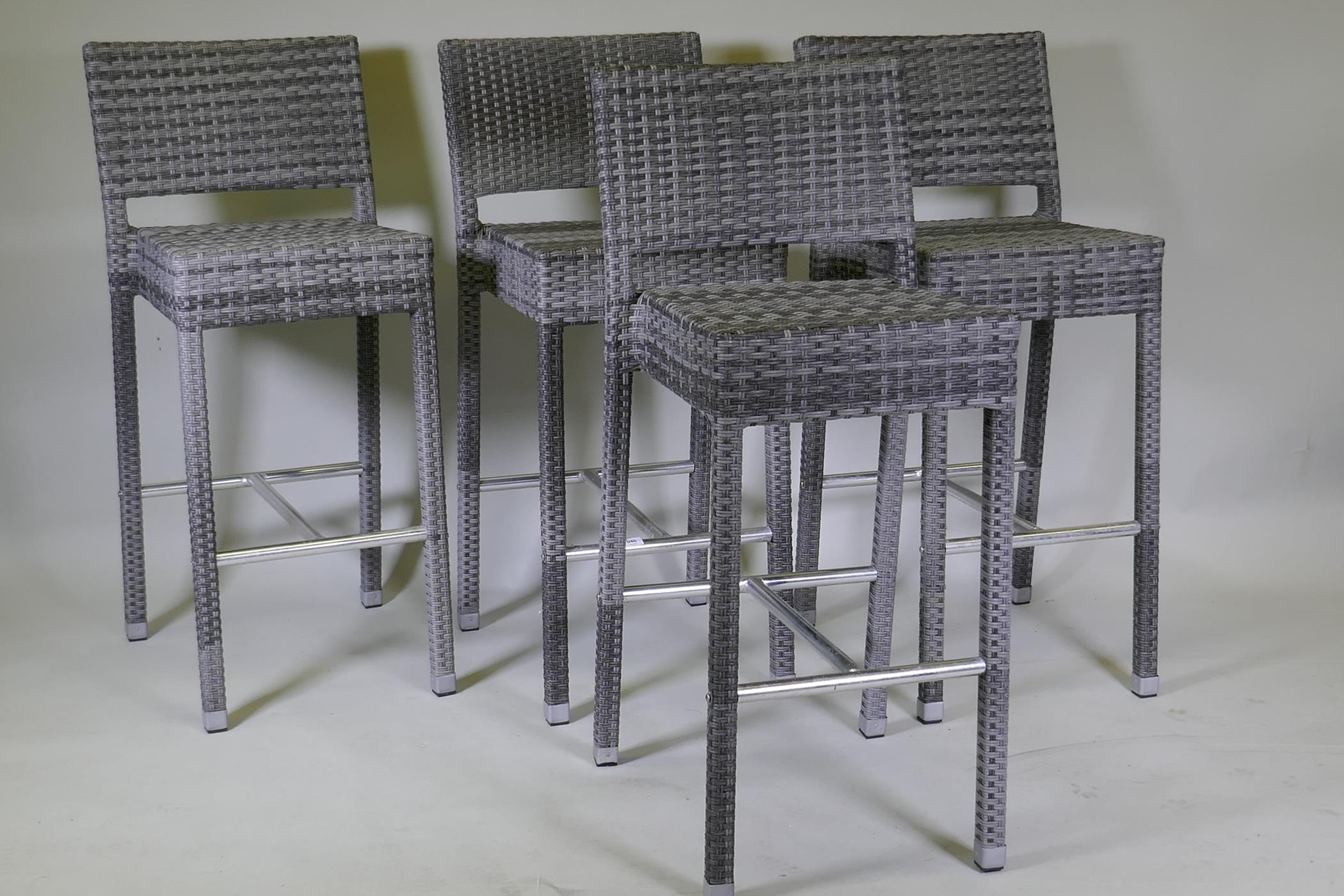A set of four cane bar stools on chrome supports, 105cm high