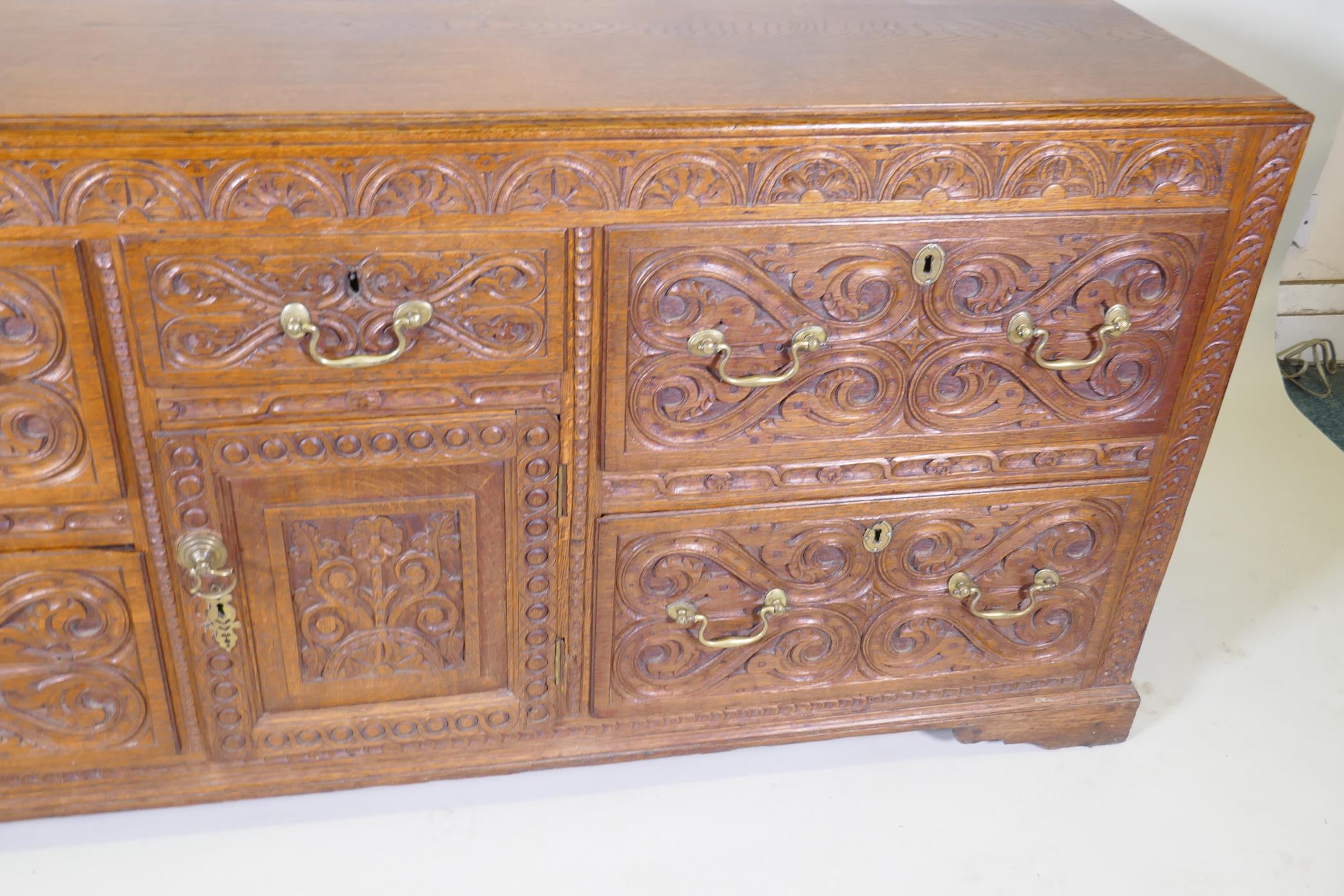 A carved oak sideboard/buffet with five drawers and a single door, with brass swan neck handles, - Image 3 of 3