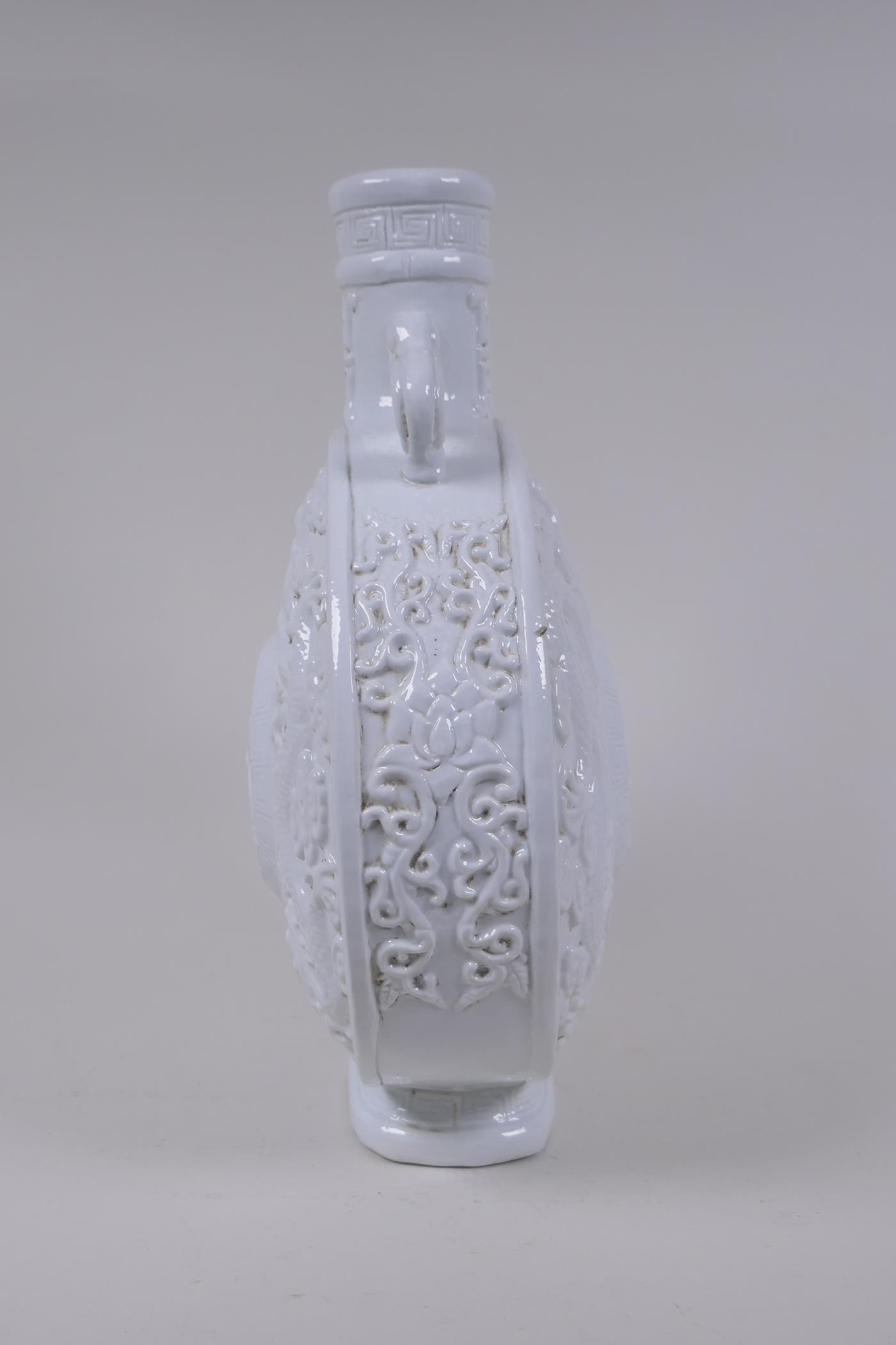 A Chinese blanc de chine porcelain two handled moon flask with raised and floral decoration, - Image 3 of 6