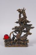 A Chinese filled bronze figure of a dragon and a red glass flaming pearl, impressed seal mark to