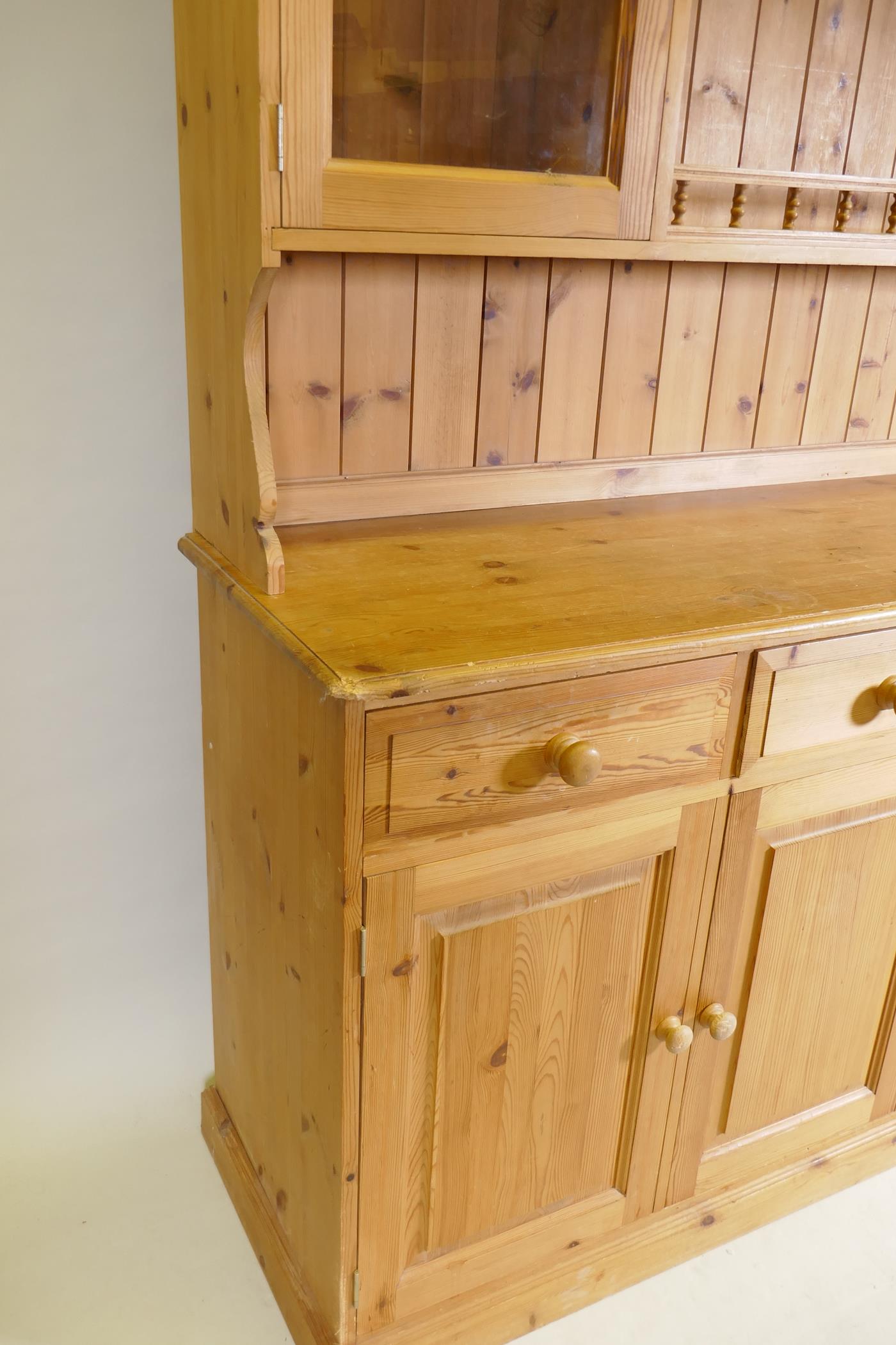 A pine dresser, the upper section with two glazed door flanking open shelves, the base with four - Image 2 of 2