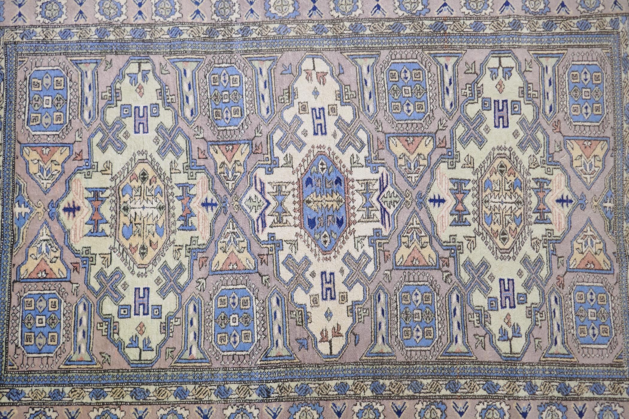 An antique Persian faded pink ground wool carpet with a green geometric medallion design, 140 x - Image 4 of 5