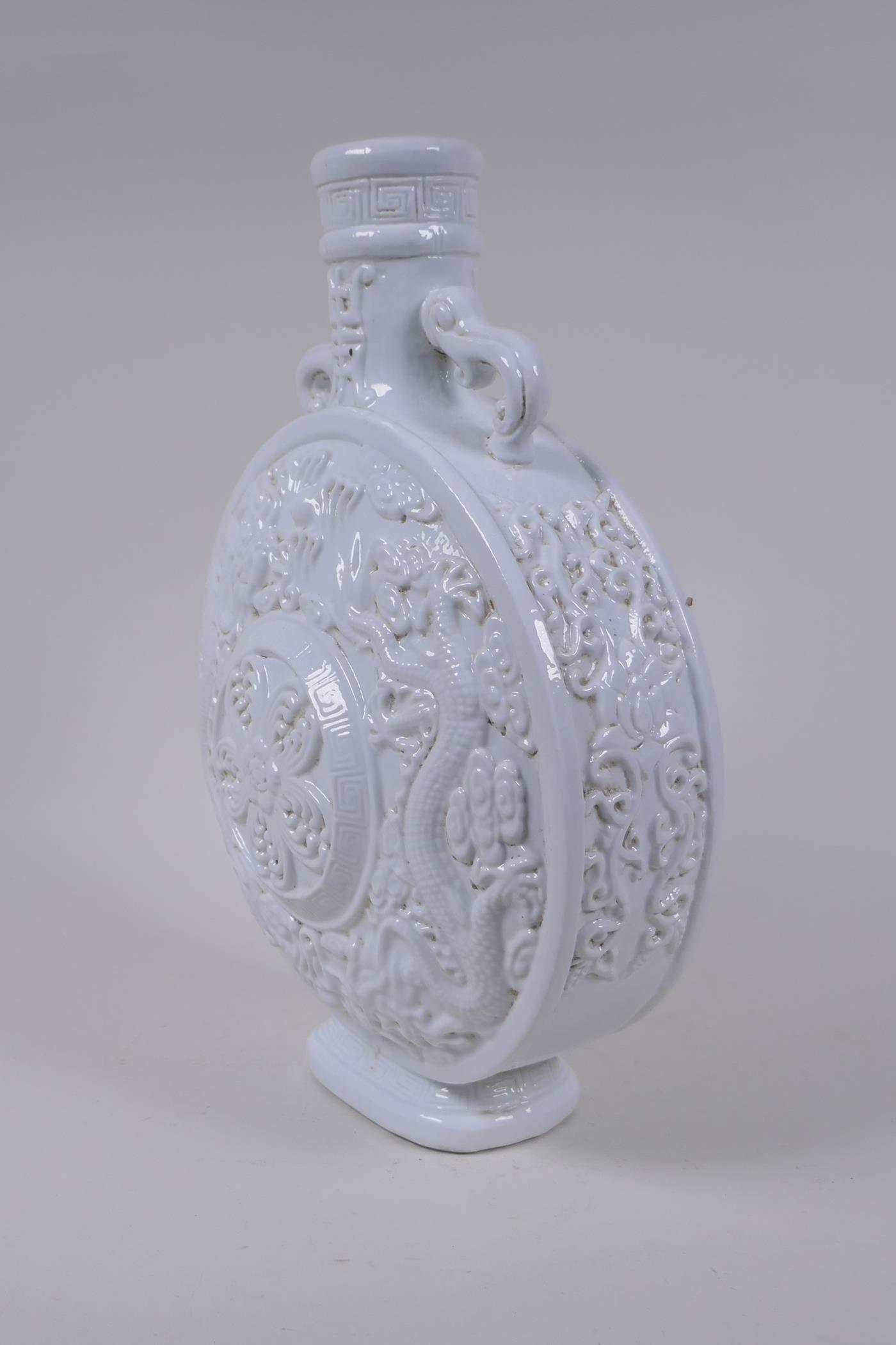 A Chinese blanc de chine porcelain two handled moon flask with raised and floral decoration, - Image 2 of 6