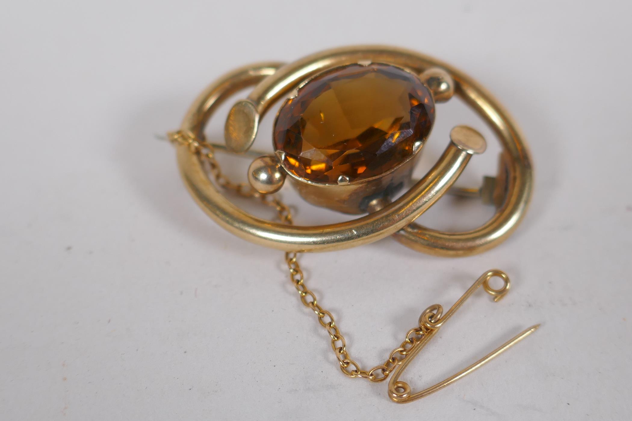 A yellow metal brooch set with a large amber coloured stone, citrine/amethyst, 11.6g