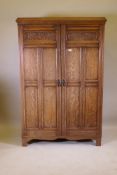 A good oak gentleman's wardrobe, with pegged joints, paneled doors and sides, and carved grape and