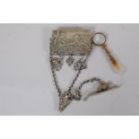 A C19th white metal chatelaine with raised classical decoration and elephant charms, 6.5cm long, and