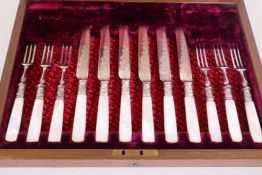 A six place set of knives and forks with mother of pearl handles, in a walnut case