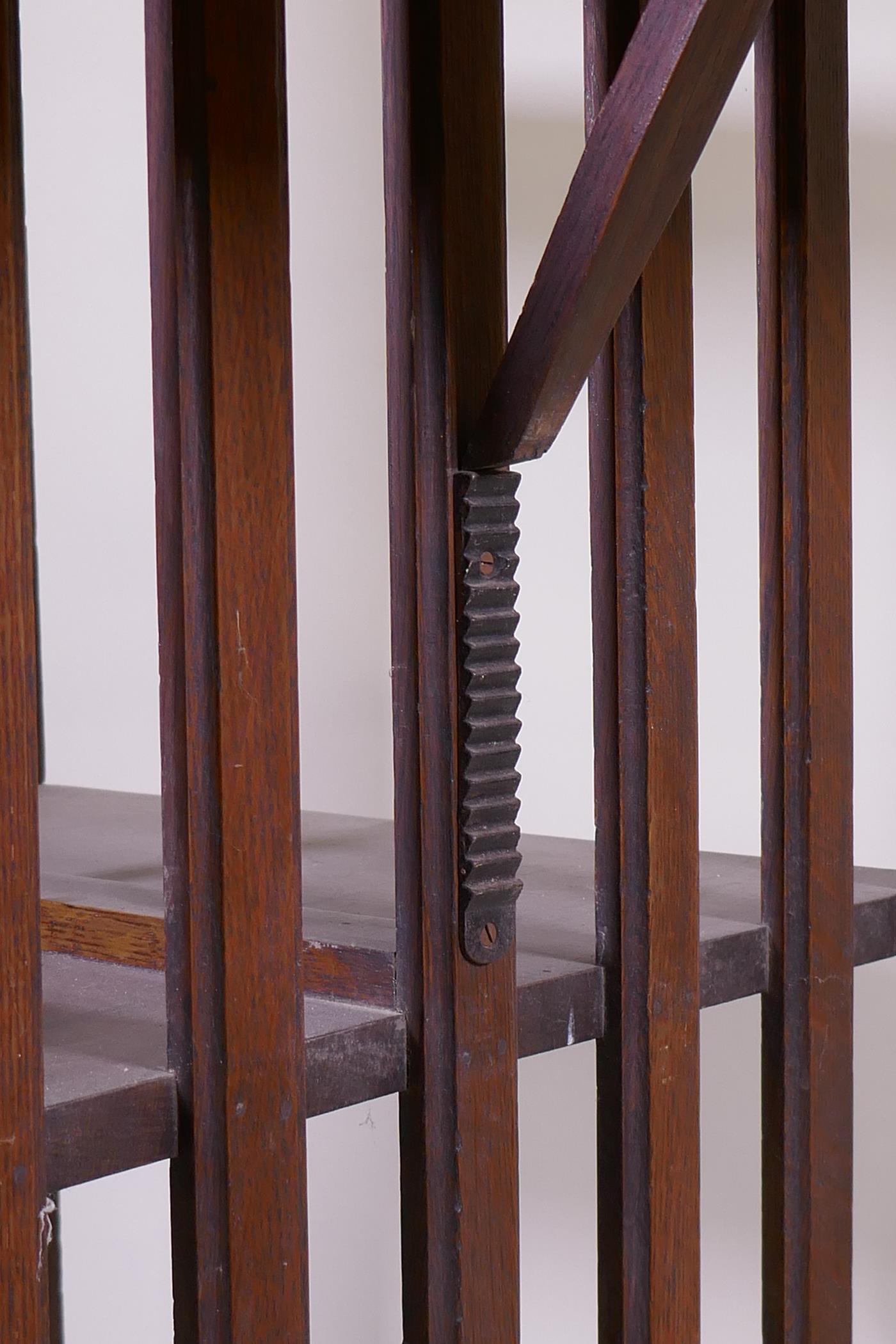 A Victorian oak revolving bookcase, three tiered with a ratcheted drop flap, raised on an iron base, - Image 3 of 4