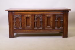 An old charm oak coffer with triple panel front and carved decoration, 113 x 52 x 45cm