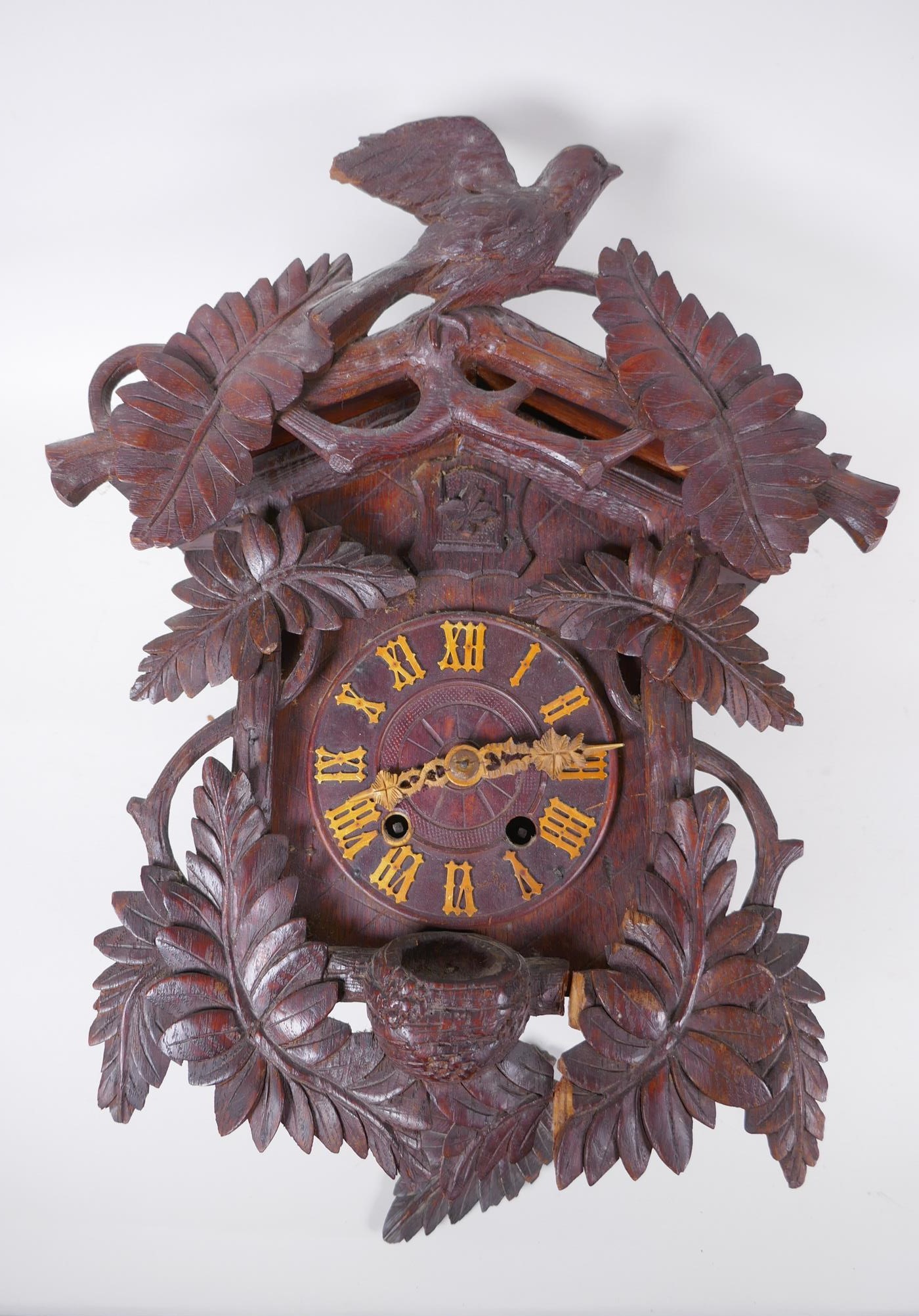 An antique carved Black Forest cuckoo clock, bellows intact, AF, 33 x 42cm