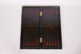 An oriental lacquered fold out games board with chequerboard and backgammon, with painted and gilded