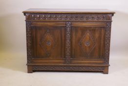 An oak blanket chest, with lift up top, carved frieze and panelled front and sides, raised on