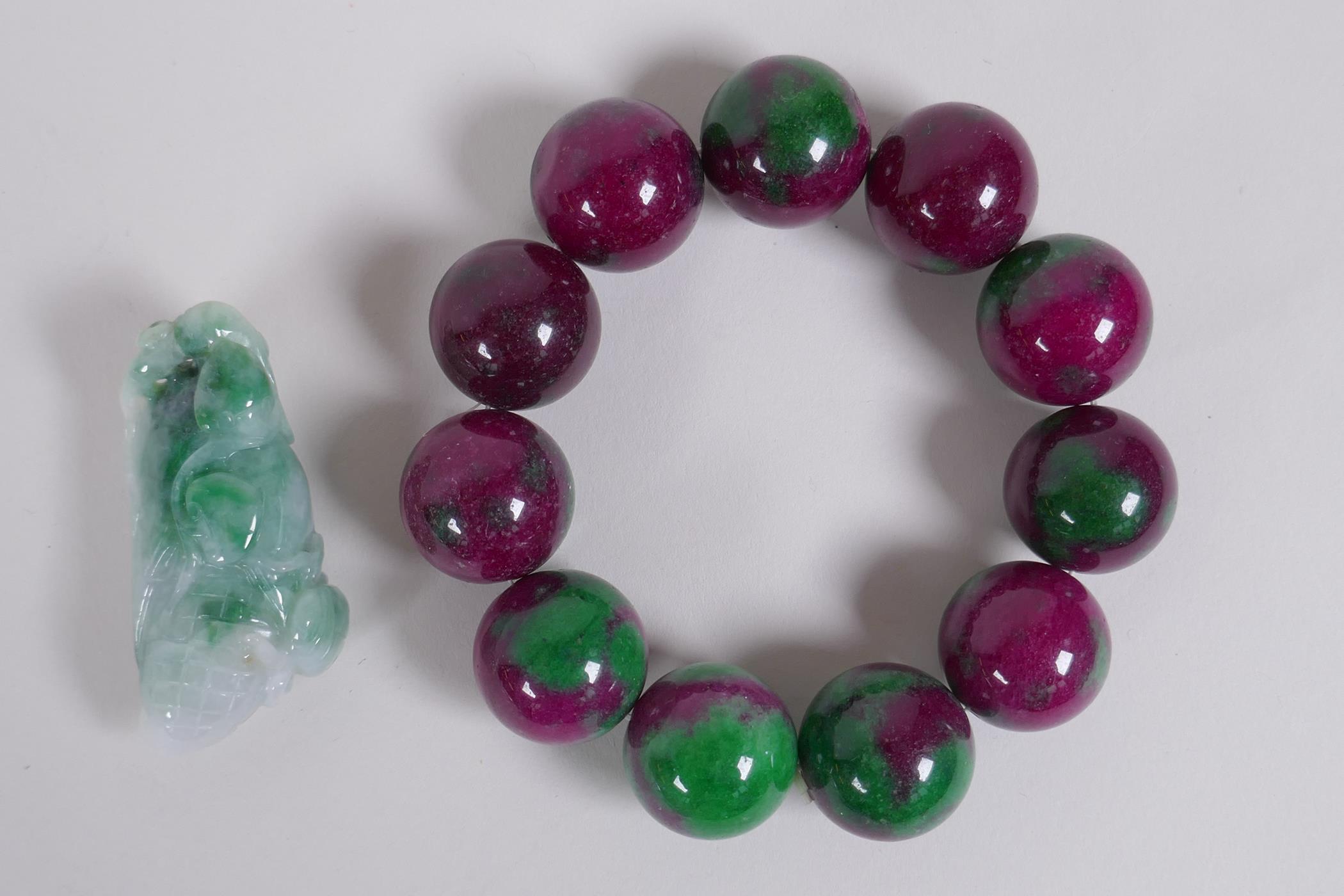 A bi colour jade bead bracelet and a Chinese carved mottled jade pendant in the form of a corn