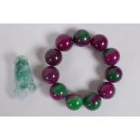 A bi colour jade bead bracelet and a Chinese carved mottled jade pendant in the form of a corn