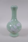 A celadon glazed porcelain garlic head shaped vase with raised white enamel decoration of birds