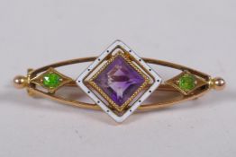 A 15ct gold suffragette brooch set with an amethyst and peridot, and enamel decoration, 3cm long, 3g