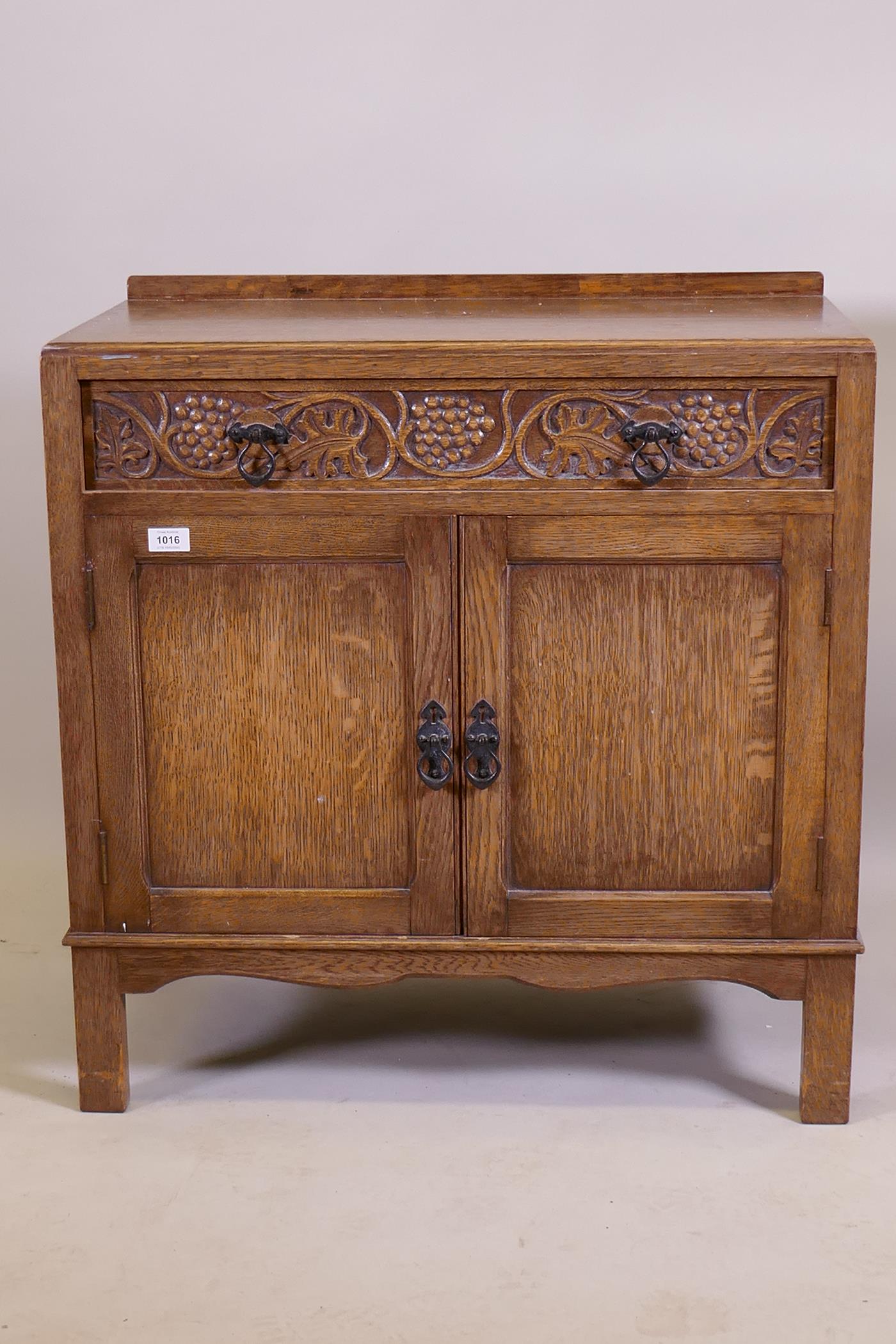 A good oak cabinet/dressing chest, with single drawer, carved grape and vine decoration, over two