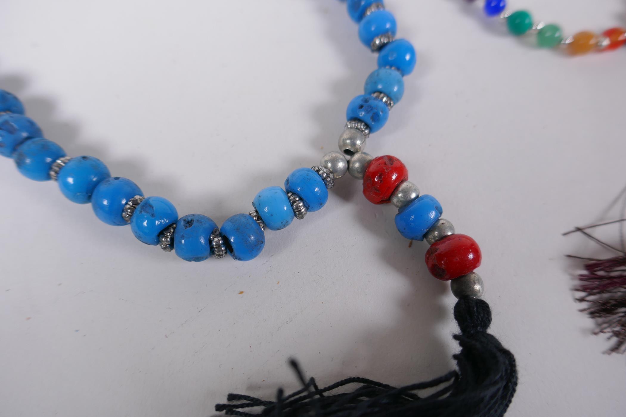 A string of blue and red glass mala beads, a string of tiger's eye mala beads, a string of dried - Image 2 of 6