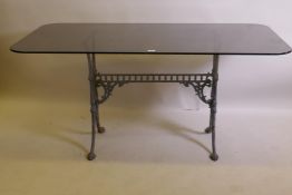 An antique painted cast iron table base with an associated glass top, 152 x 81cm, 72cm high