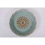 A Chinese celadon glazed porcelain dish with frilled rim and impressed character inscription to