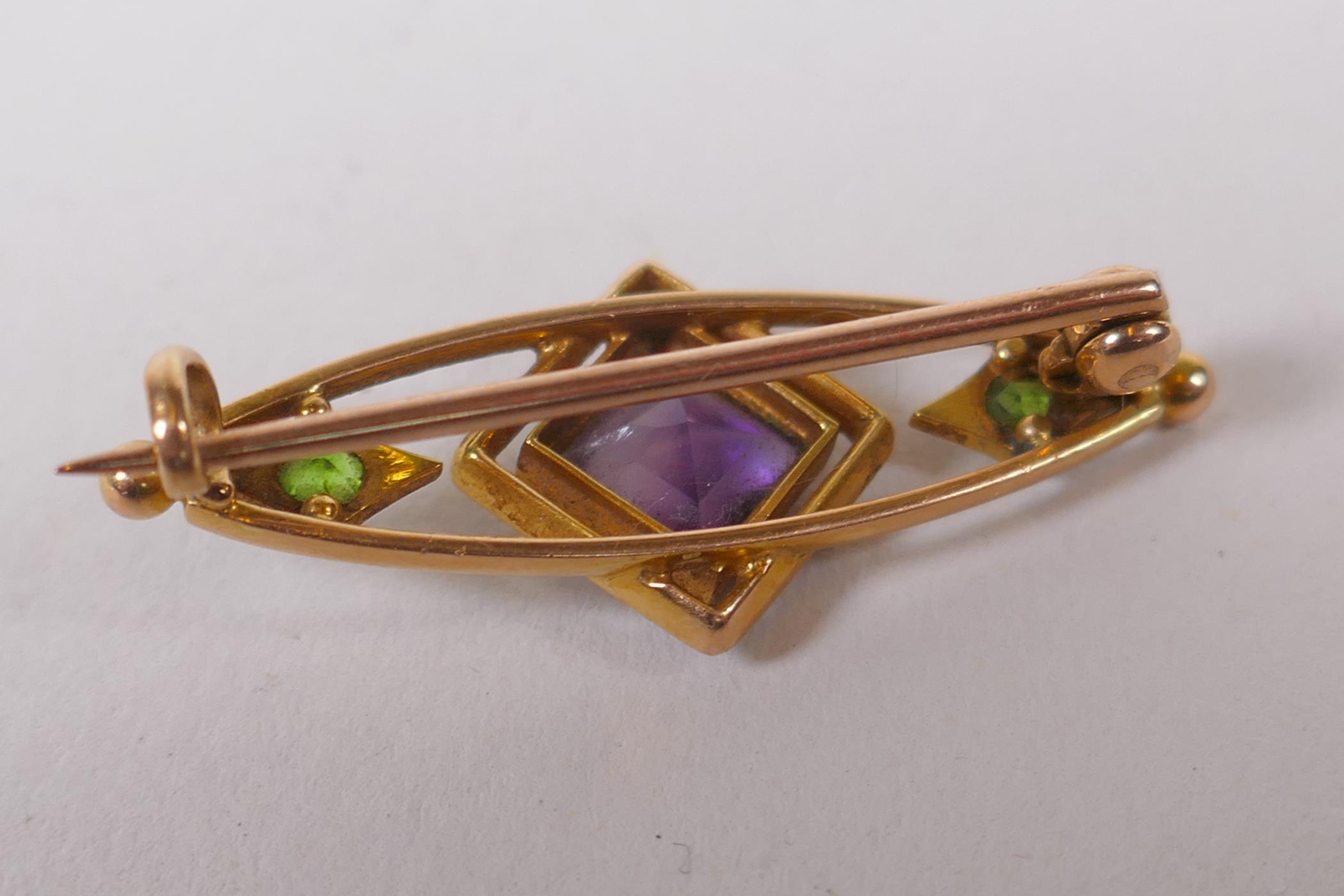 A 15ct gold suffragette brooch set with an amethyst and peridot, and enamel decoration, 3cm long, 3g - Image 4 of 4