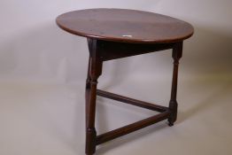 A Georgian oak cricket table on turned legs, 71cm diameter, 65cm high