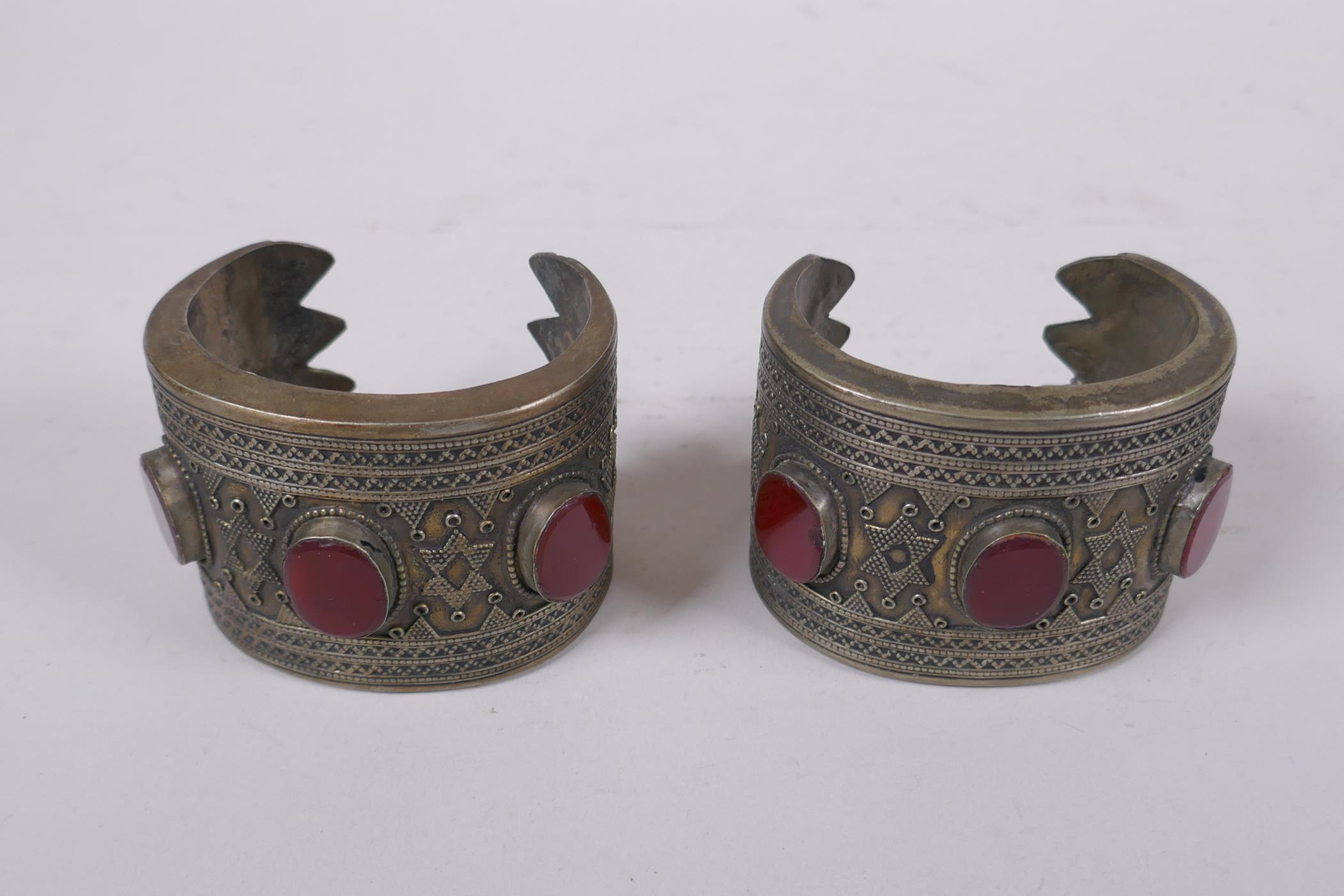 A pair of Turkmen white metal bangles set with red semi precious stones, 8 x 6cm - Image 2 of 3