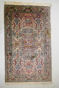 An ivory ground silk Turkmen rug with multicolour floral design, 94 x 154cm