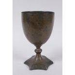 An early Nepalese/Tibetan bronze chalice with a star shaped foot and archaic inscriptions, 17cm high